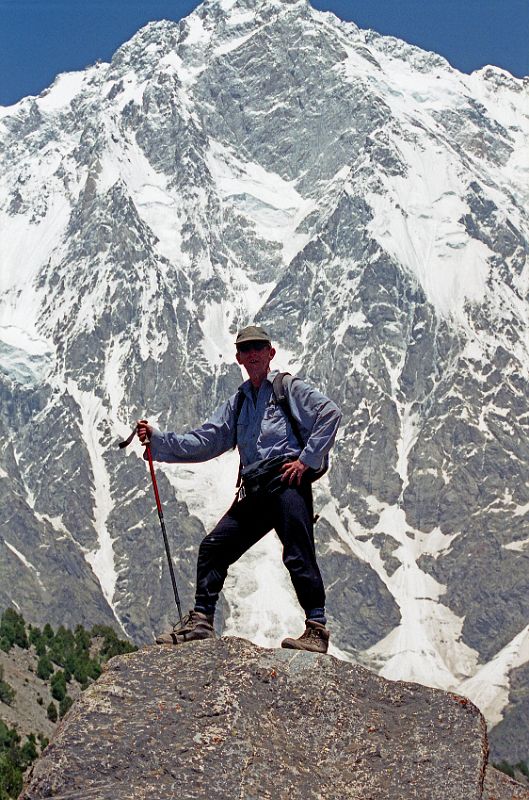 18 Jerome Ryan At Nanga Parbat Rupal Face Base Camp Jerome Ryan poses at Nanga Parbat Rupal Face Herligkoffer Base Camp with the awesome Rupal Face behind.